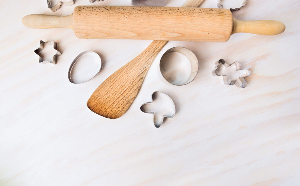 Baking tools and easter cookie cutters on white wooden background