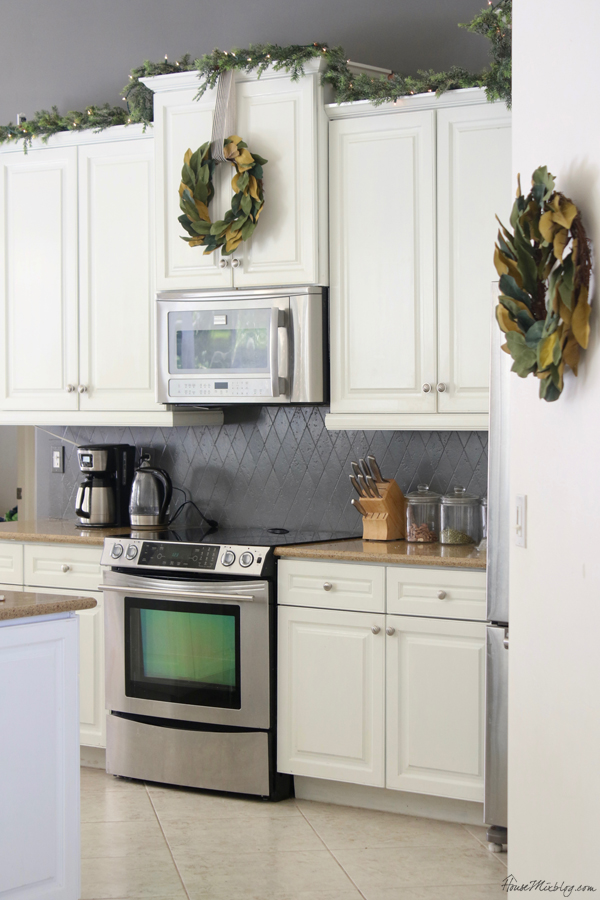 white cabinets with think garland and sparse light strand 