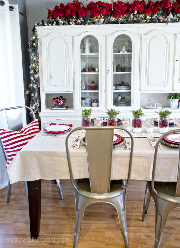 White kitchen cabinet with green garland and red poinsettias behind