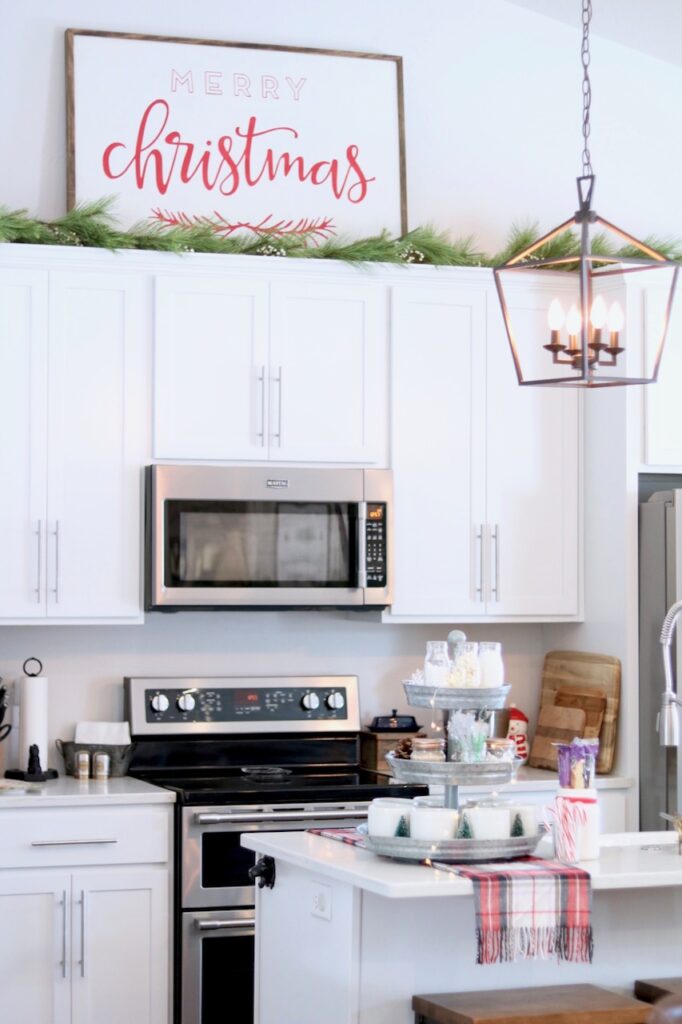white cabinets with garland and Merry Christmas sign 