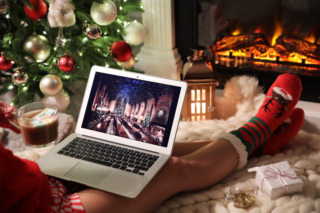 Woman with sweet drink watching Harry Potter and Philosopher's Stone movie on laptop near fireplace 
