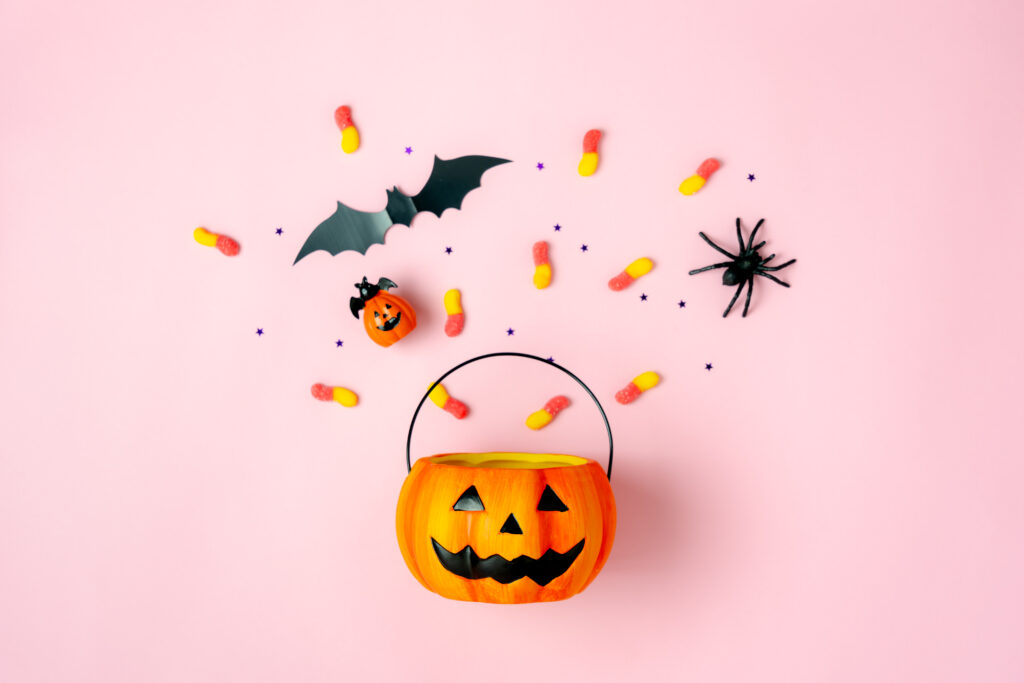 Plastic orange pumpkin bucket with candy and spider ring. 
