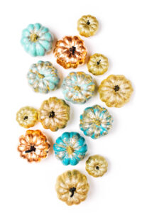 teal, orange and yellow pumpkins on a white background