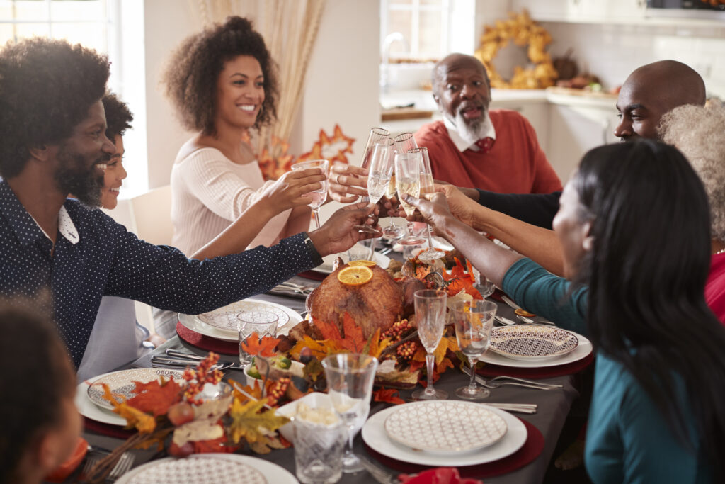 family at thanksgiving table with garland at center