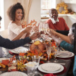 family at thanksgiving table with garland at center